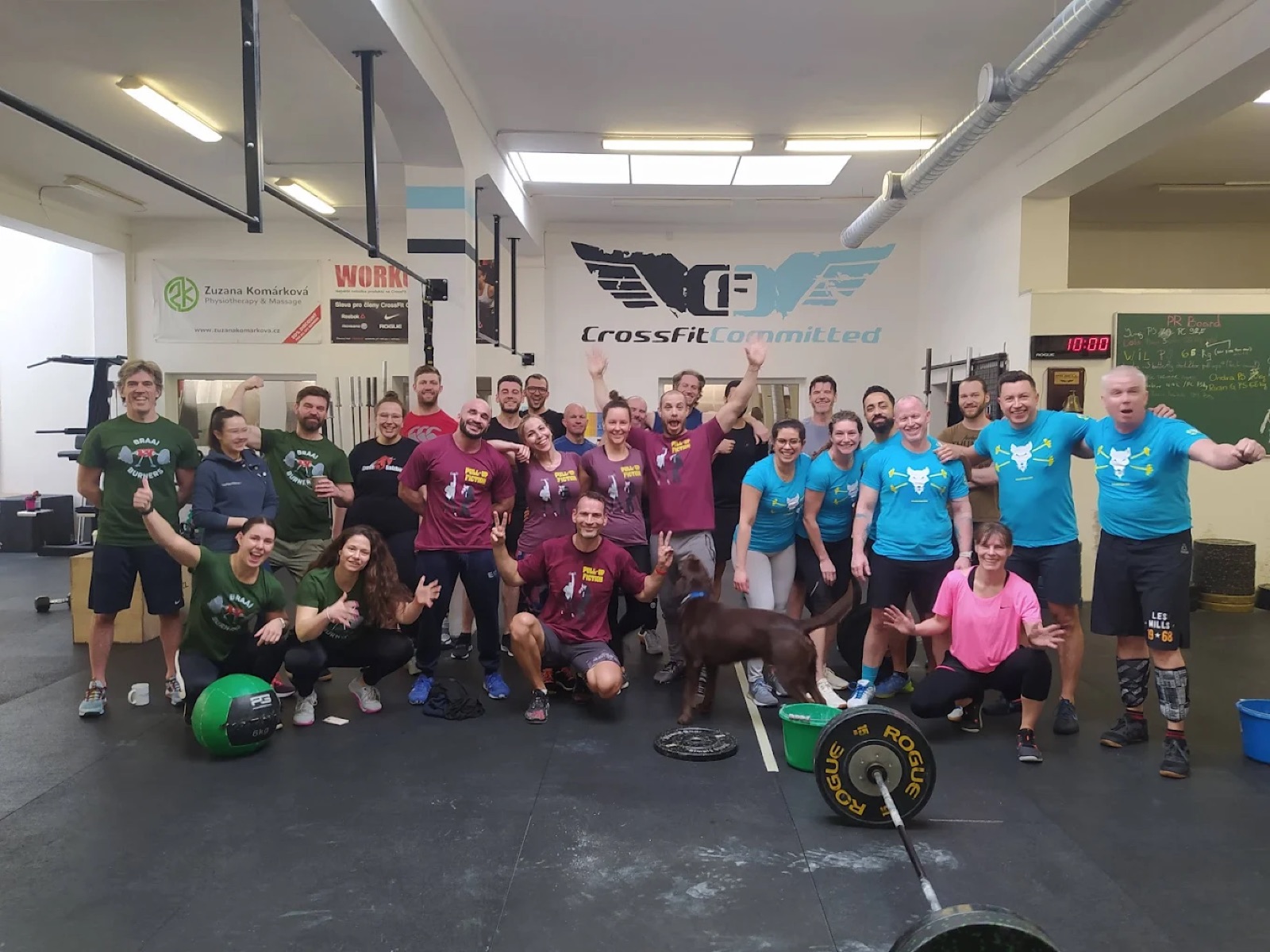 The CrossFit Committed community after a class, arms up, dog included