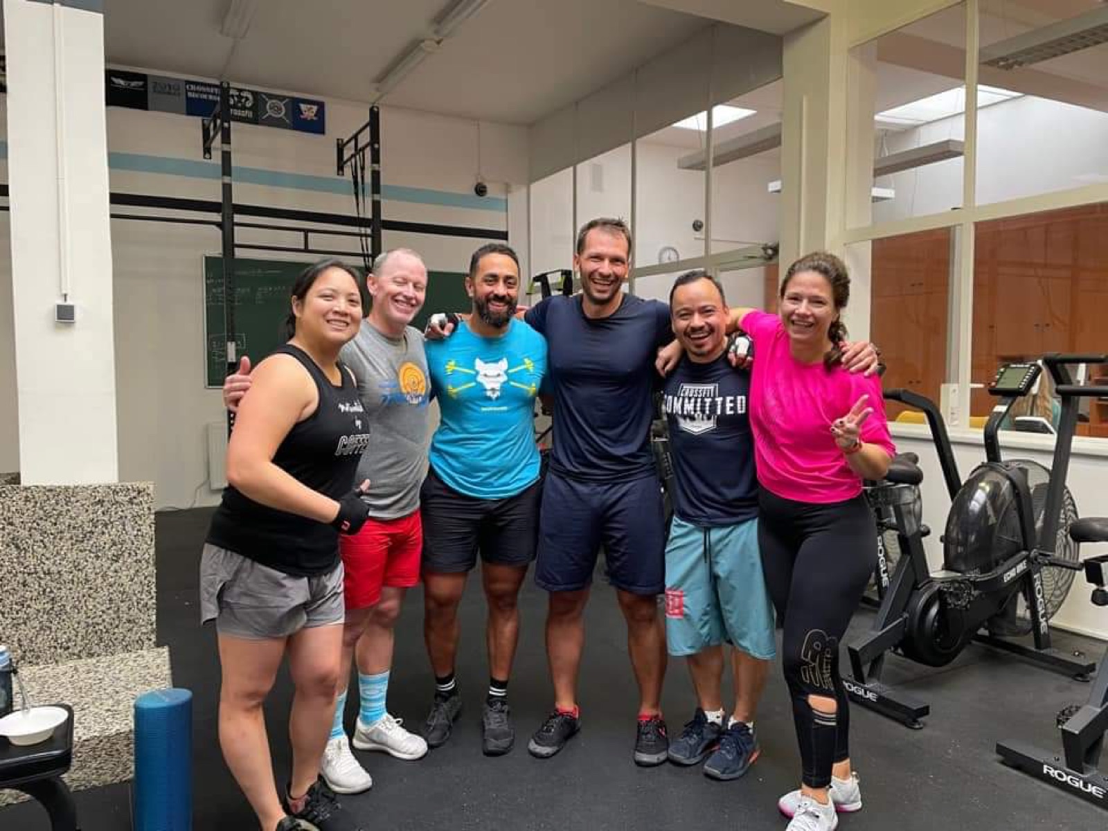 Joey and members with their arms around each other, laughing after a workout