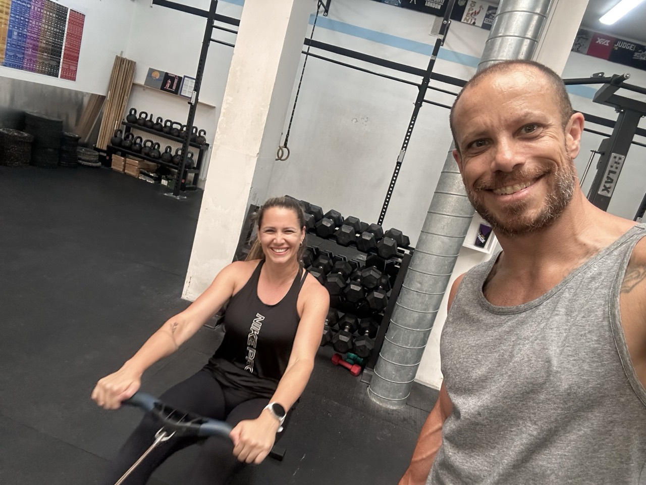 Joey coaching a member one on one on the rower