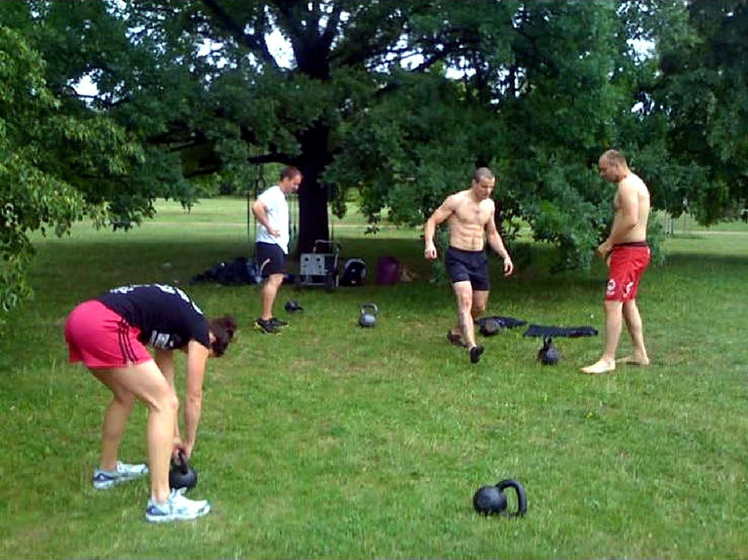 Archive photo from 2011: a small group training with kettlebells on the grass in Letná park